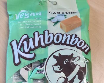 Eine schwarz-grün-weiße Verpackung vegane Kuhbonbons.